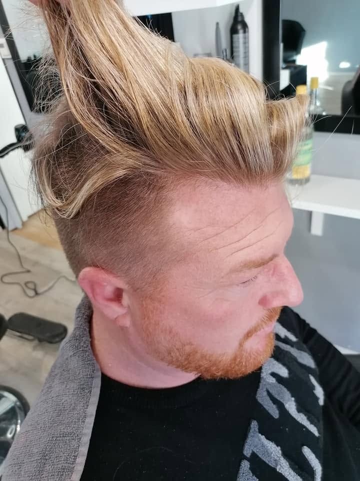 Pán s vysoko vyčesaným blond vrškem po střihu