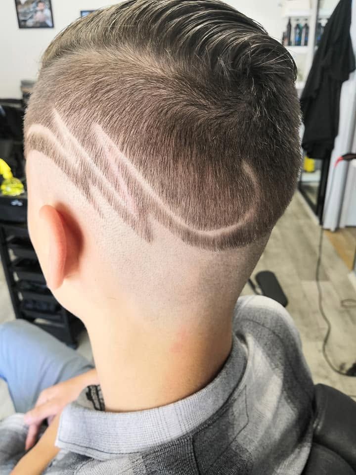 Pohled zezadu na pánský fade s vyholeným vzorem